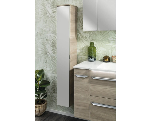 Moderner Badezimmer-Hochschrank und Unterschrank in Holzoptik mit hellen Fronten vor einer Tapete mit Palmenmuster.