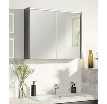 Armoire de toilette à deux portes au-dessus d'un lavabo clair dans une salle de bains moderne avec distributeur de savon et robinet.