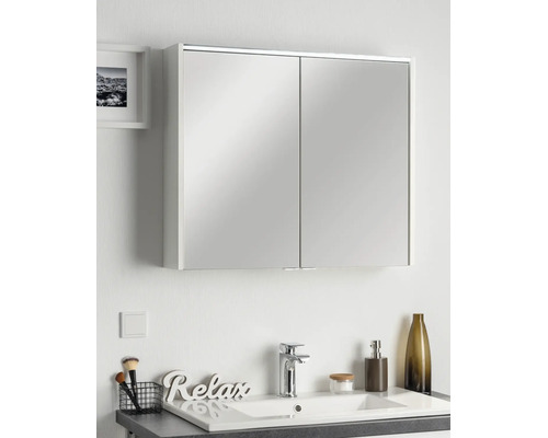 Armoire de toilette à deux portes dans une salle de bains moderne au-dessus d'un lavabo avec robinet et décoration.