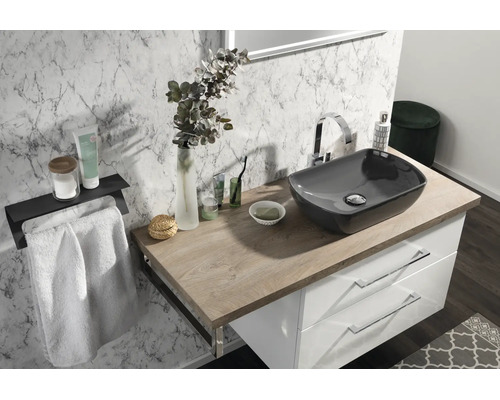 Salle de bain moderne avec vasque à poser grise sur plan de travail en bois, meuble sous-vasque blanc et carrelage mural effet marbre.