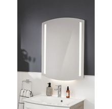 Miroir de salle de bain avec éclairage LED latéral et inférieur, forme bombée, monté au-dessus d'un lavabo dans une salle de bain moderne.