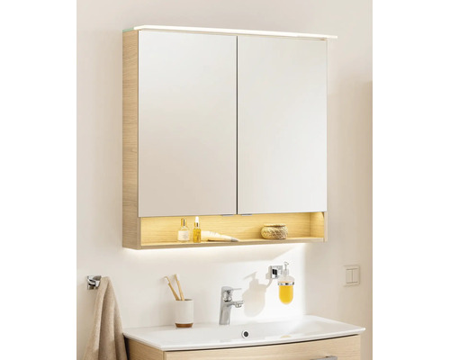 Armoire de toilette à deux portes aspect bois, éclairage LED en haut et en bas et rangement ouvert au-dessus d'un lavabo.