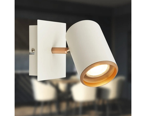 Applique murale orientable en blanc et cuivre avec tête cylindrique et plaque de montage rectangulaire.