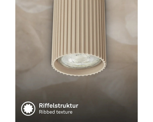 Vue détaillée d une applique de plafond cylindrique avec une structure de surface nervurée.