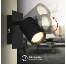 Applique murale noire avec tête de lampe orientable et nervurée pour un éclairage ciblé.