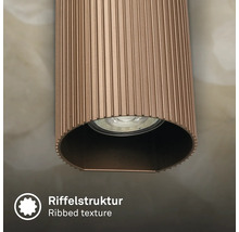 Vue détaillée d'un luminaire cylindrique avec une structure de surface nervurée et une source lumineuse intégrée.