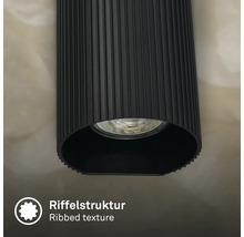 Gros plan d un luminaire cylindrique avec une structure de surface nervurée et une source lumineuse intégrée.