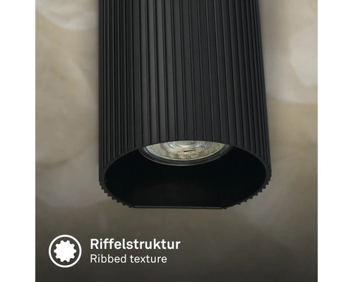 Gros plan d un luminaire cylindrique avec une structure de surface nervurée et une source lumineuse intégrée.