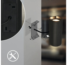 Schéma technique de l'installation d'une applique murale cylindrique avec support, vis, câble et symbole de montage.