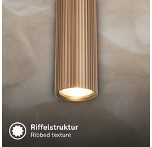 Détail d'un luminaire cylindrique avec structure nervurée.