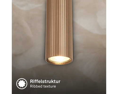 Détail d'un luminaire cylindrique avec structure nervurée.