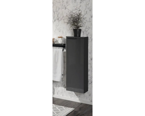 Schmaler, wandhängender Badezimmerschrank in Anthrazit an einer Wand in Marmoroptik neben einem Handtuchhalter.