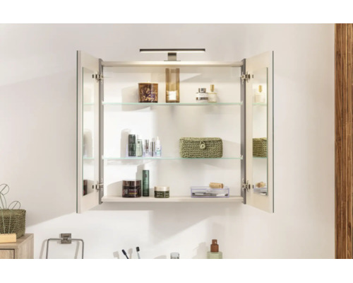 Armoire de toilette ouverte avec deux portes miroir, trois tablettes en verre et éclairage LED. Contient divers produits cosmétiques.