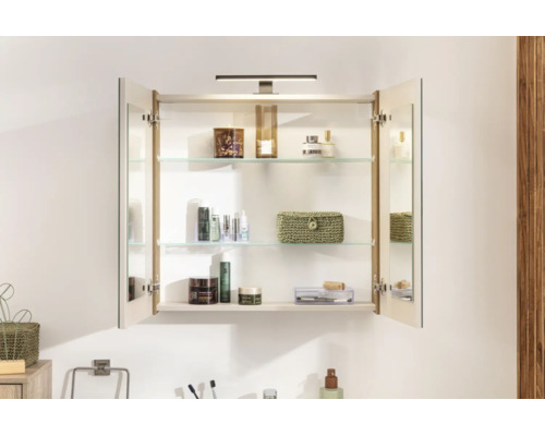 Armoire de toilette avec deux portes ouvertes, miroir, applique LED et étagères en verre, contenant divers produits de soin.