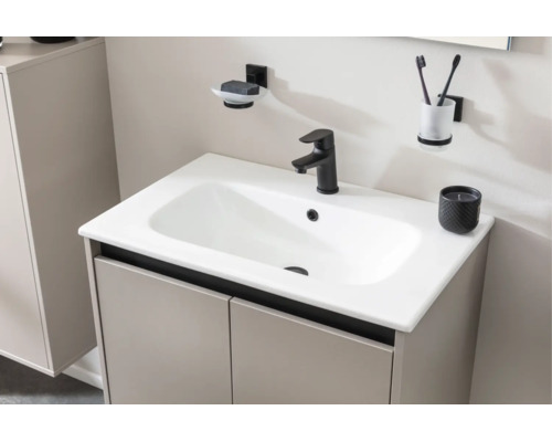 Lavabo moderne avec vasque céramique blanche, robinetterie noire, meuble bas beige et accessoires muraux assortis dans la salle de bains.