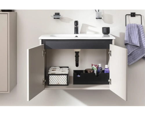 Meuble sous-vasque suspendu moderne avec portes ouvertes, lavabo en céramique et robinetterie en métal. Intérieur organisé avec des paniers.