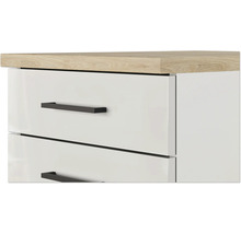 Gros plan d'une commode blanche avec des tiroirs, des poignées noires et un plateau en aspect chêne.