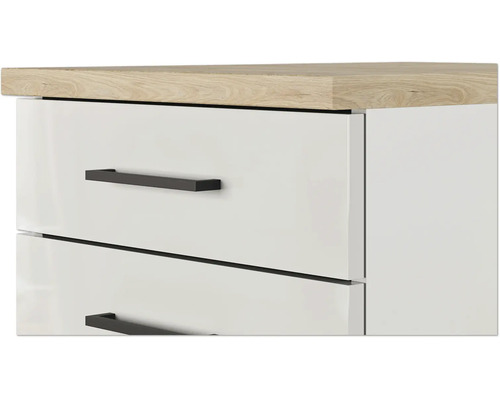 Gros plan d'une commode blanche avec des tiroirs, des poignées noires et un plateau en aspect chêne.