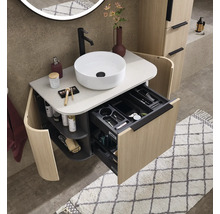 Meuble de salle de bain moderne aspect bois avec vasque ronde, robinet noir et tiroir ouvert avec compartiments de rangement.