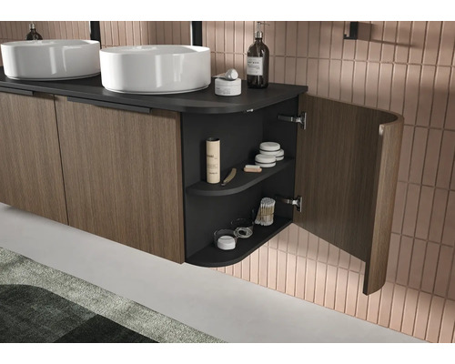 Meuble de salle de bains double vasque moderne avec façades en lattes de bois, plan de travail sombre et étagère latérale courbe ouverte.
