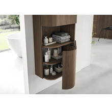 Armoire de toilette suspendue moderne avec rainures verticales en bois et porte arrondie, contenant serviettes et produits de soin.