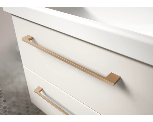 Gros plan d'un meuble sous-lavabo blanc avec deux tiroirs et de longues poignées métalliques de couleur cuivre.
