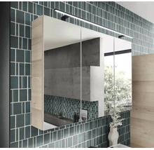 Armoire de toilette moderne à 3 portes avec éclairage LED et aspect bois sur un mur carrelé dans une salle de bains lumineuse et ordonnée.