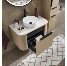 Meuble sous-vasque avec vasque à poser aspect bois à structure rainurée, un tiroir ouvert, salle de bains organisée.