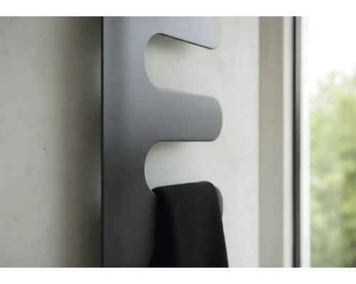 Radiateur design moderne gris foncé avec une serviette noire au mur.