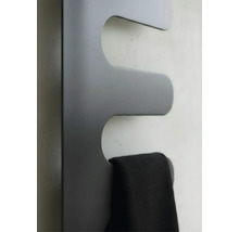Radiateur sèche-serviettes en forme de vague avec une serviette suspendue.
