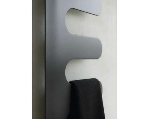 Radiateur sèche-serviettes en forme de vague avec une serviette suspendue.