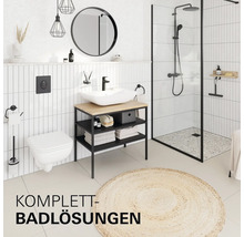 Salle de bains moderne avec carrelage blanc, toilettes suspendues, meuble vasque en bois, robinetterie noire et douche avec paroi vitrée.