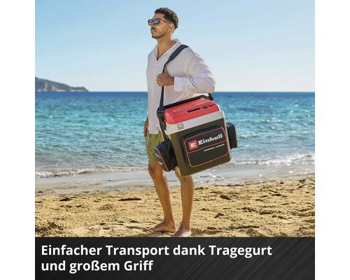 Glacière Einhell avec bandoulière, grande poignée et poche pour accessoires, portée par un homme sur une plage de sable lumineuse.