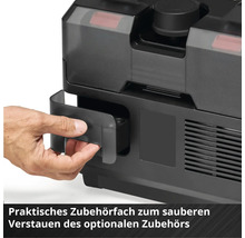 Une main ouvre un compartiment à accessoires intégré sur un appareil noir pour le rangement des accessoires.