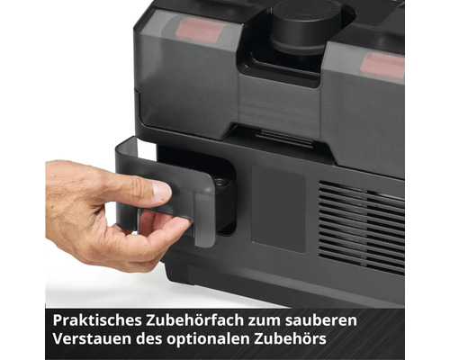 Une main ouvre un compartiment à accessoires intégré sur un appareil noir pour le rangement des accessoires.