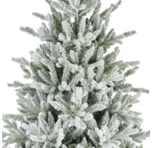 Nahaufnahme eines künstlichen Weihnachtsbaums mit verschneiten Zweigen und grünen Nadeln.