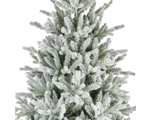 Nahaufnahme eines künstlichen Weihnachtsbaums mit verschneiten Zweigen und grünen Nadeln.