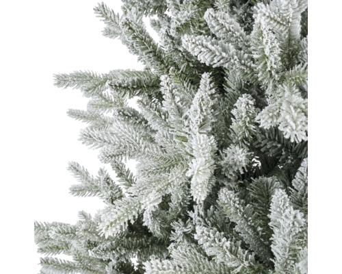 Detailansicht der beschneiten Zweige einer künstlichen Tanne für die Weihnachtsdekoration.