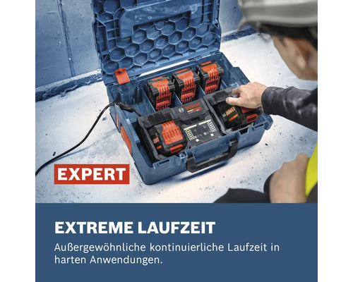 Arbeiter setzt Bosch Expert 18V Akku in Mehrfach-Ladegerät in L-BOXX auf Baustelle ein. Organisierte Arbeitsumgebung. Bosch Logo vorhanden.