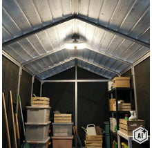 Vue intérieure d une cabane de jardin avec éclairage, étagères, bacs en plastique et caisses en bois pour le rangement d outils de jardinage. (Image AI modified or generated)