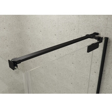 Barre de stabilisation en métal noir pour parois de douche en verre, fixée sur un mur clair à l'aspect pierre.