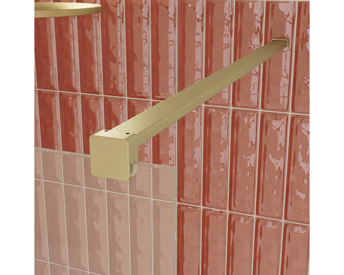 Goldfarbene, quadratische Stabilisierungsstange für eine Duschkabine aus Glas, an einer gefliesten Wand montiert.