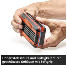 Des mains tiennent une batterie Einhell avec un boîtier Softgrip pour une protection élevée contre les chocs.