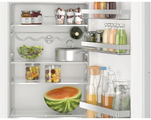 Vue intérieure d un réfrigérateur Bosch avec étagères en verre remplies, porte-bouteilles et balconnets de porte pour un rangement organisé.
