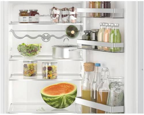 Vue interieure d un refrigerateur Bosch avec clayettes en verre, porte bouteilles, balconnets de porte et pots remplis et une pasteque.