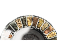 Tambour d'un distributeur de nourriture pour poissons, rempli de différents aliments comme des flocons, des comprimés et des granulés.