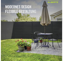 Clôture occultante Alberts anthracite dans le jardin derrière un salon de jardin avec table, chaises et parasol.
