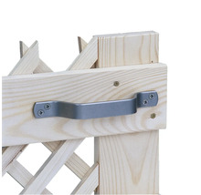 Gros plan d'une poignée en métal gris sur une barrière extensible en bois clair.