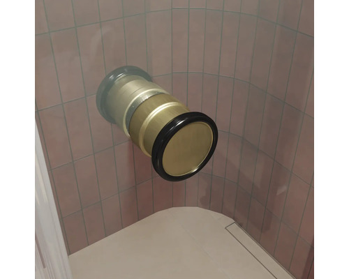 Ein in die Wand eingelassenes Wannen- oder Duschanschlussstück aus Metall mit Dichtungsring vor einer gefliesten Wand.