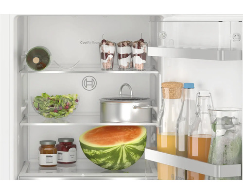 Réfrigérateur Bosch ouvert avec clayettes en verre et balconnets de porte remplis de produits alimentaires.
